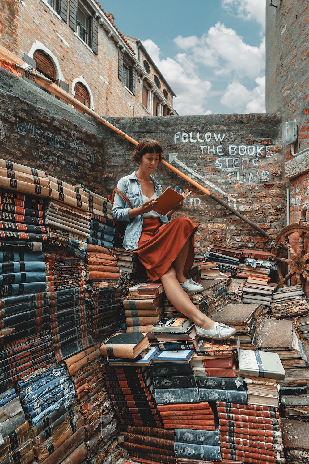 woman sitting on books